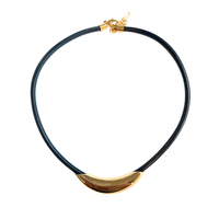 A black braided cord necklace with a polished gold crescent-shaped centerpiece and a gold lobster clasp, shown on a plain white background.