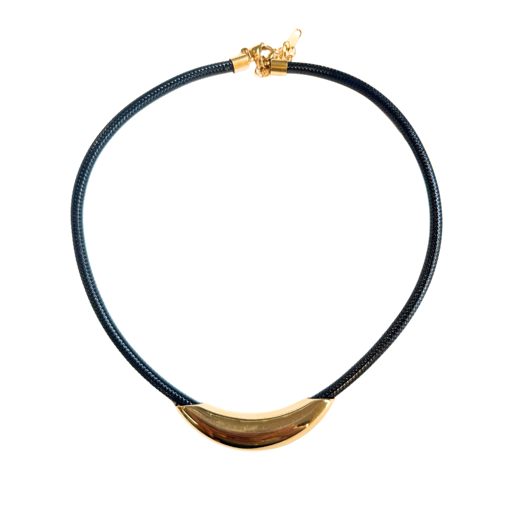 A black braided cord necklace with a polished gold crescent-shaped centerpiece and a gold lobster clasp, shown on a plain white background.