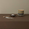 Stacked ceramic plates on a brown surface with a beige wall background