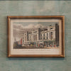 Framed vintage print of a city street scene on a textured wall.