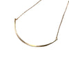 Gold necklace on a textured beige fabric background