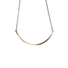 Gold necklace on a textured stone surface