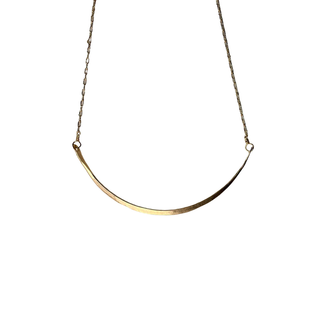 Gold necklace on a textured stone surface