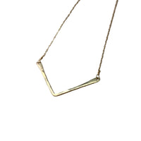 Gold necklace on a textured gray surface
