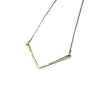 Gold necklace on a textured gray surface