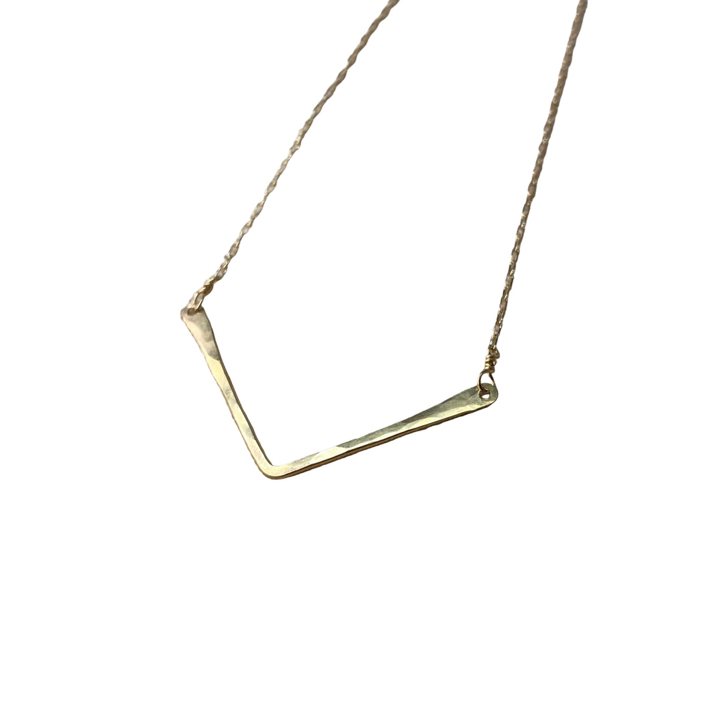 Gold necklace on a textured gray surface