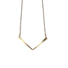 Gold necklace with a V-shaped pendant on a textured stone surface