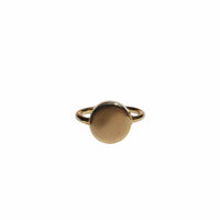 Gold ring with a circular design on a light gray background