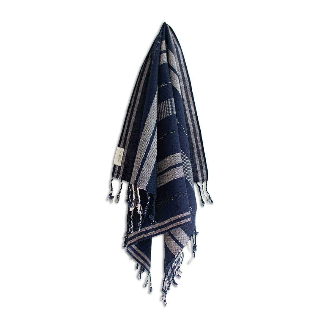 Navy and gray striped towel with tassels on a white background