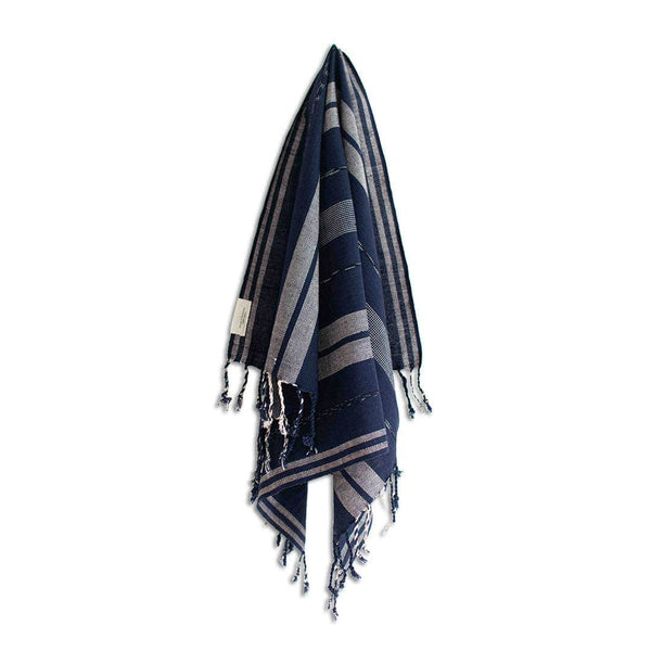 Navy and gray striped towel with tassels on a white background