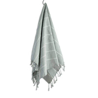 Green towel with white stripes and tassels on a white background