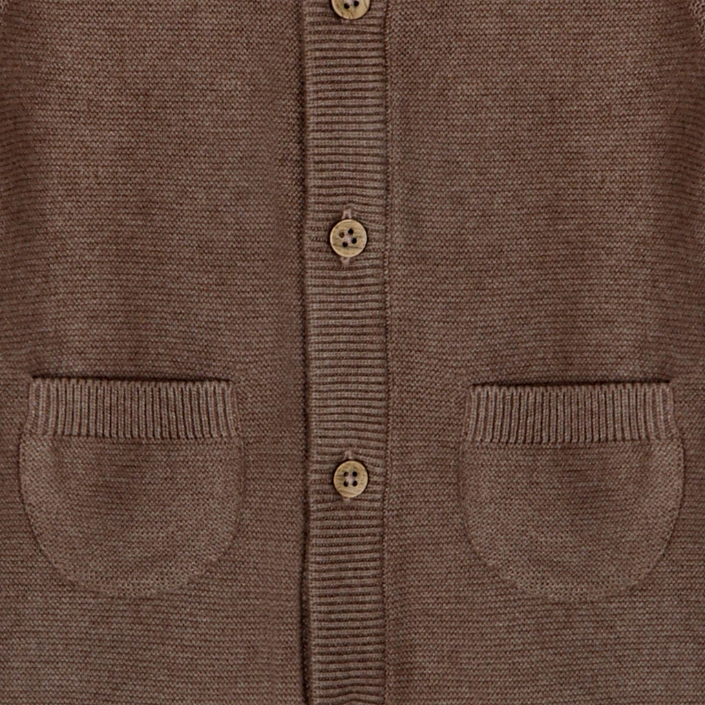 Close-up of a brown cardigan with button details and two pockets.