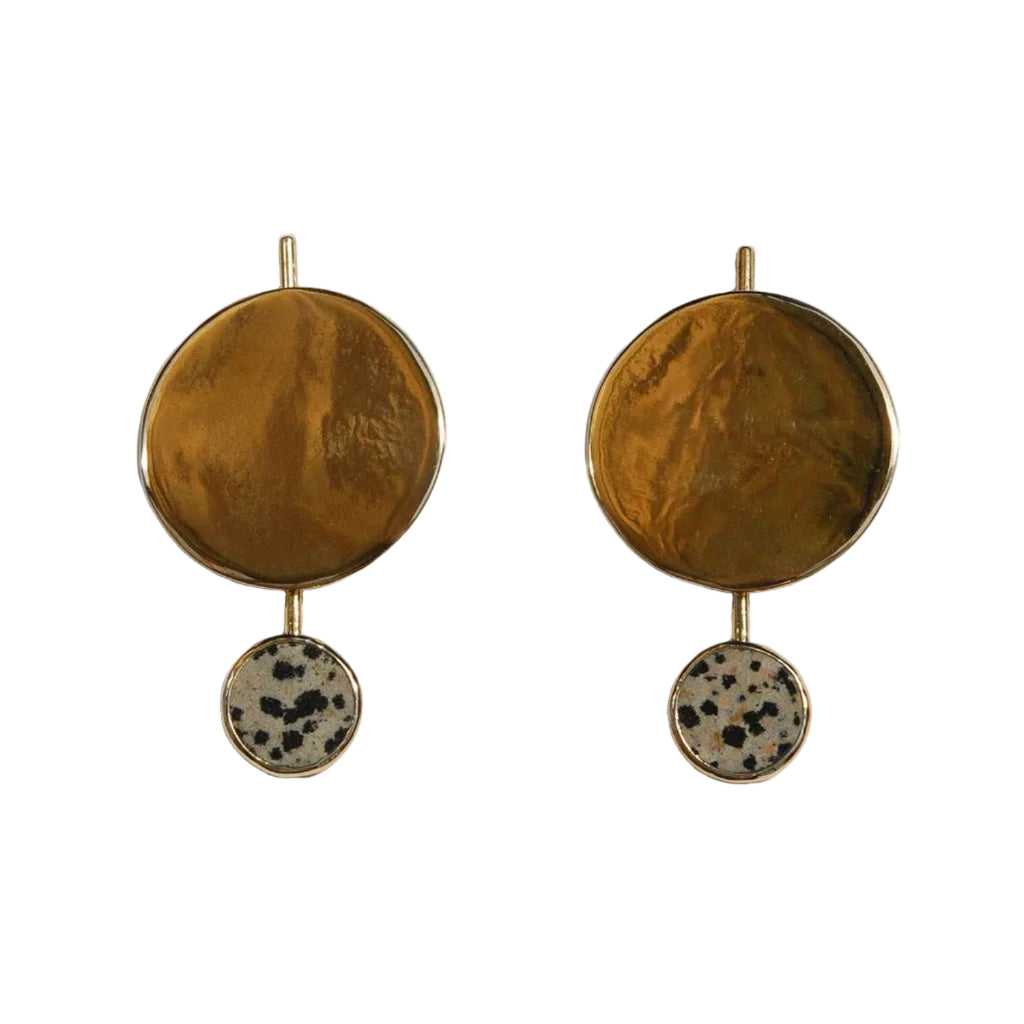 Pair of brass earrings with round top and spotted bottom on a white background