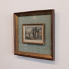 Framed artwork of a cityscape on a light gray wall