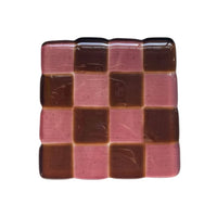 Glass coaster with checkered pattern on a white surface with decorative items.