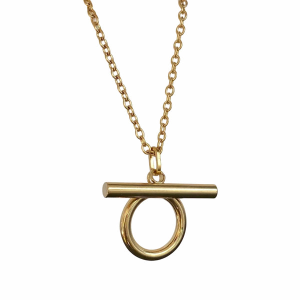 Gold necklace with a unique pendant on a white geometric background