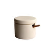 Small ceramic container with a lid on a gray surface