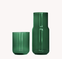 Green glass carafe and tumbler on a white background