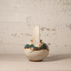 Small ceramic vase with a textured surface on a plain background