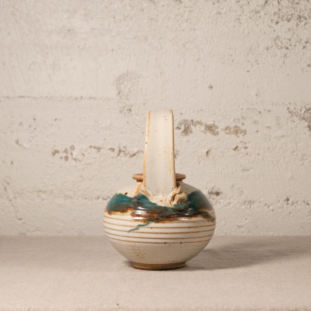 Small ceramic vase with a textured surface on a plain background