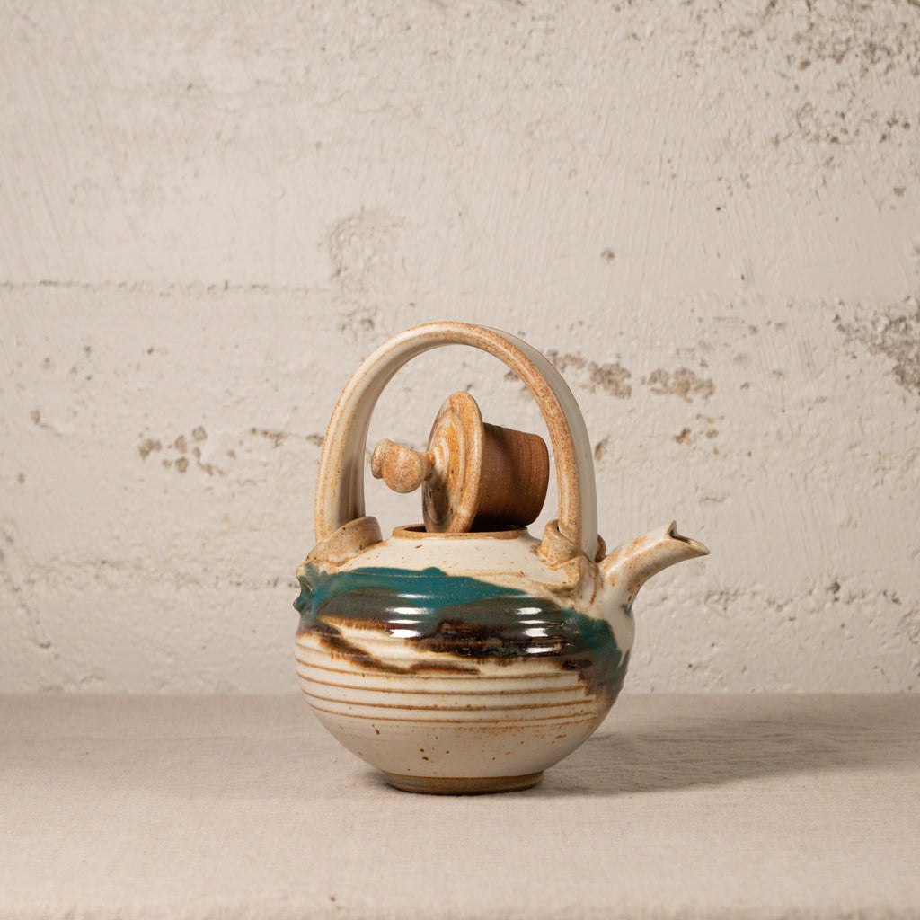 Ceramic teapot on a textured surface
