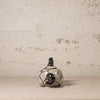 Small ceramic teapot with black and blue patterns on a textured beige background