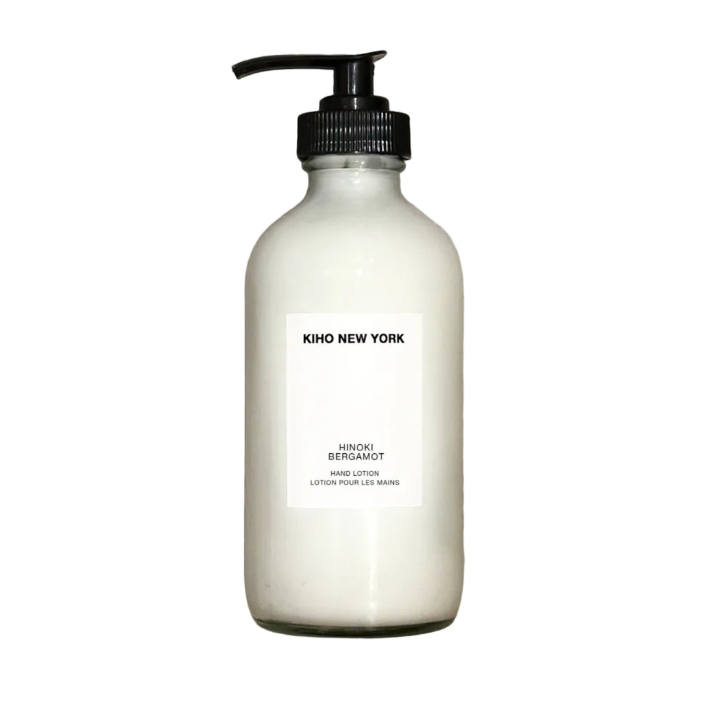 White bottle with black pump labeled 'Kiko New York' on a beige stone background