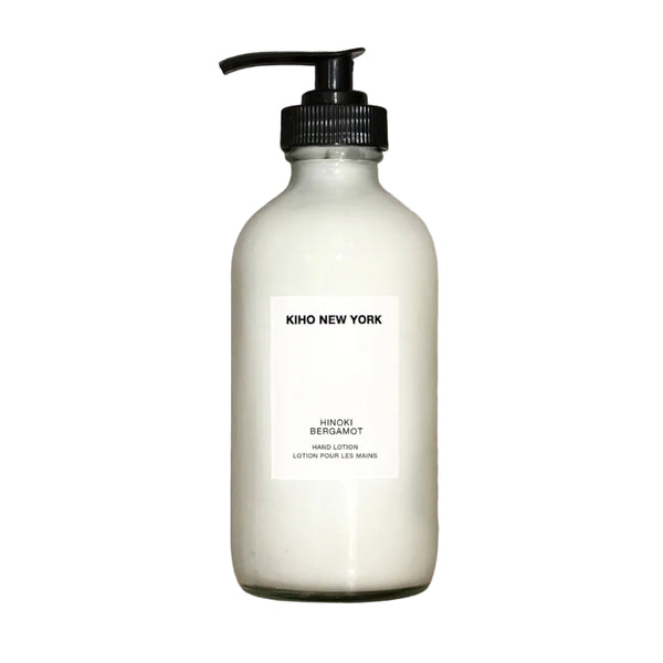 White bottle with black pump labeled 'Kiko New York' on a beige stone background
