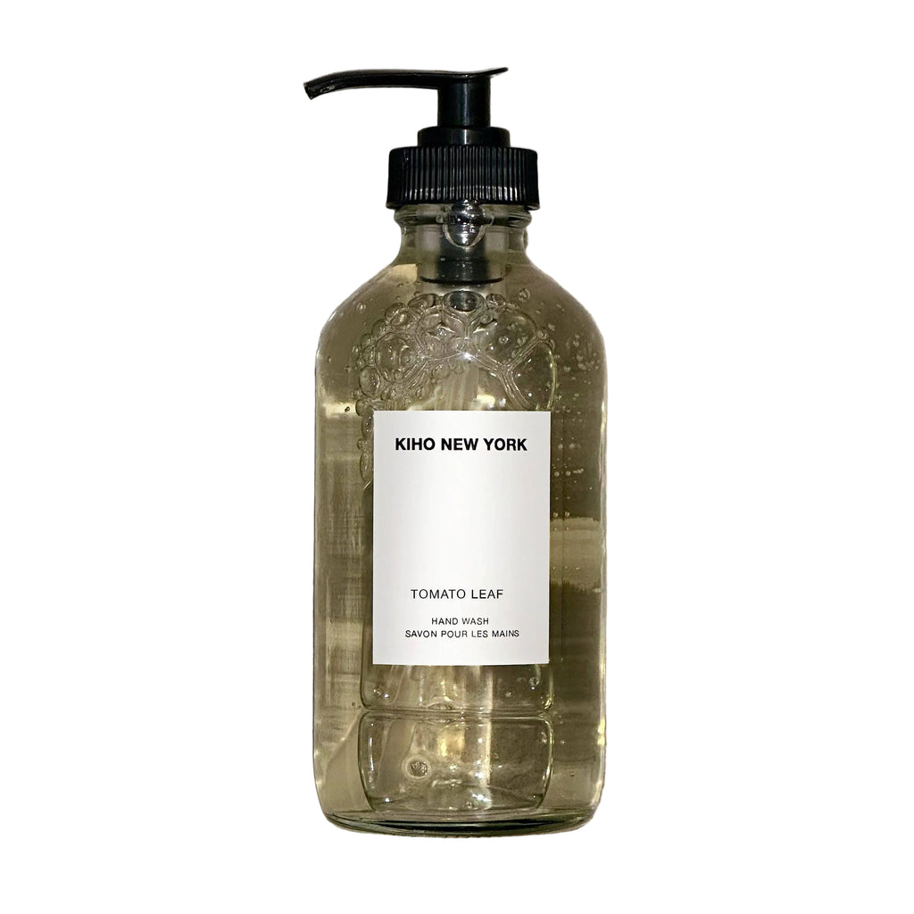 Glass bottle with pump and 'Kiko New York' label on a textured gray background