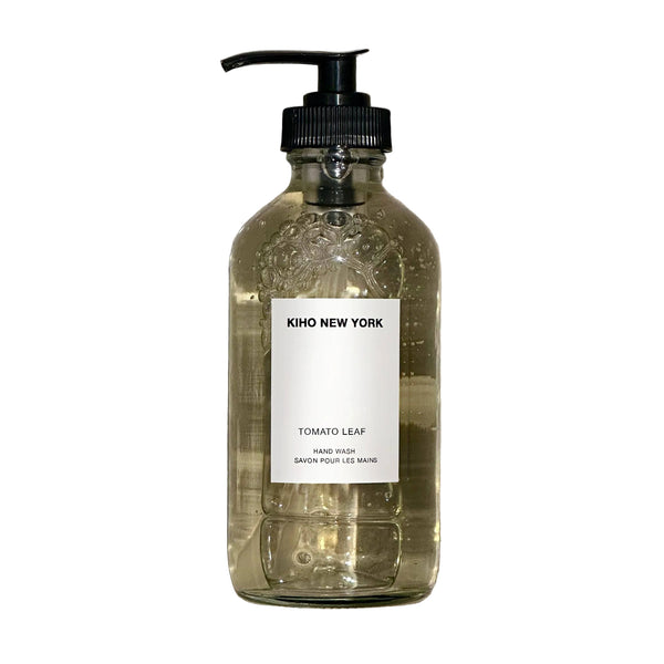 Glass bottle with pump and 'Kiko New York' label on a textured gray background
