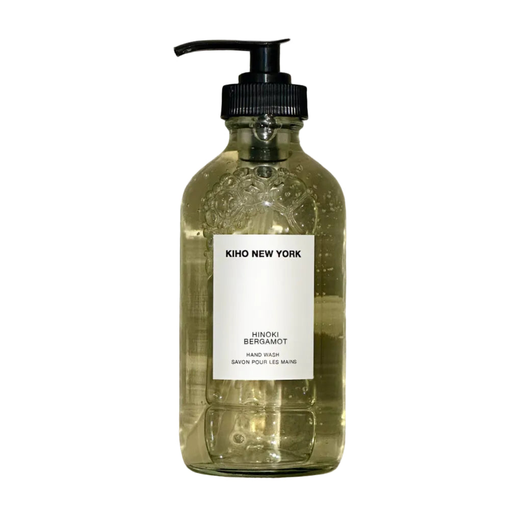 Glass bottle with pump and label on a textured gray background