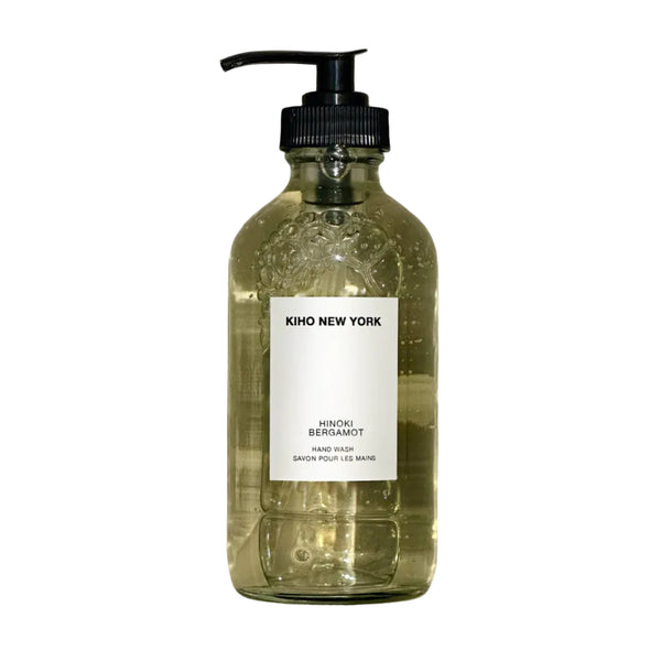 Glass bottle with pump and label on a textured gray background