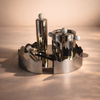 Metallic candle holder with three cylindrical candles on a beige background
