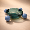 Glass bowl with blue spherical elements on a beige background