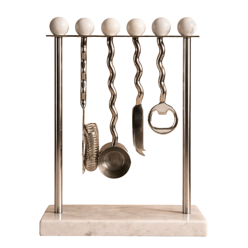 Set of kitchen utensils on a decorative stand with marble base against a beige background