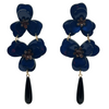 Pair of blue flower-shaped earrings with black teardrop pendants on a white background