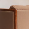 Image features the corner of a brown mid-century modern wool sofa with a wooden frame against a white background.