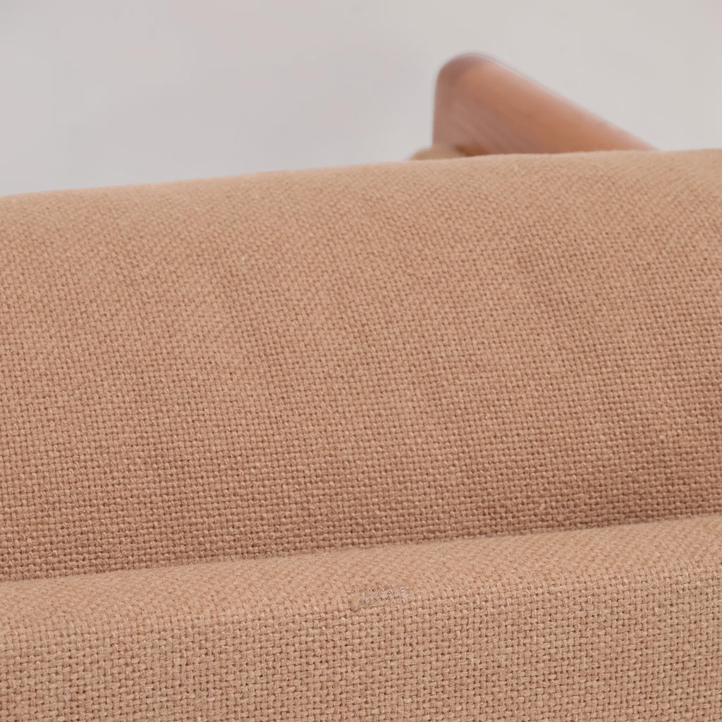 Image features the cushion of a brown mid-century modern wool sofa with a wooden frame against a white background.