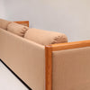Image features a corner of a brown mid-century modern wool sofa with a wooden frame against a white background.