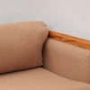 Image features the corner cushion of a brown mid-century modern wool sofa with a wooden frame against a white background.