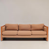 Image features a brown mid-century modern wool sofa with a wooden frame against a white background.