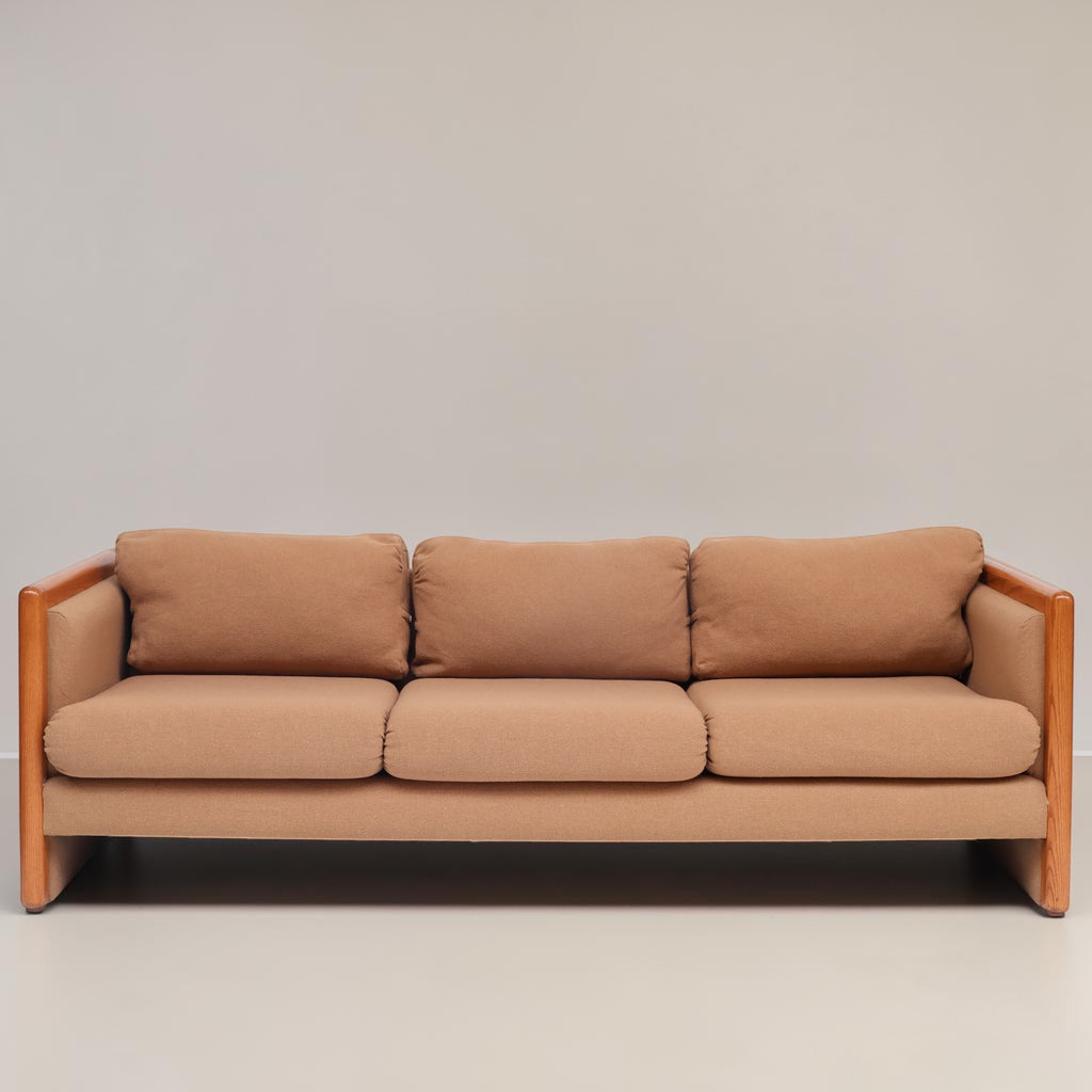 Image features a brown mid-century modern wool sofa with a wooden frame against a white background.