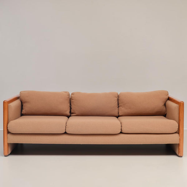 Image features a brown mid-century modern wool sofa with a wooden frame against a white background.