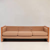 Image features a brown mid-century modern wool sofa with a wooden frame against a white background.