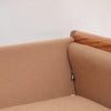 Image features the corner of a brown mid-century modern wool sofa with a wooden frame against a white background.