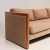 Image features the side of a brown mid-century modern wool sofa with a wooden frame against a white background.