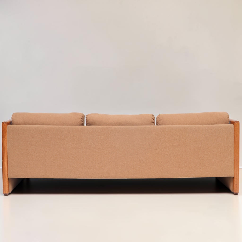 Image features the back of a brown mid-century modern wool sofa with a wooden frame against a white background.