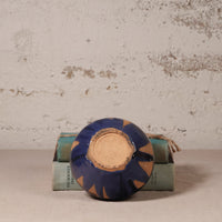 Ceramic dish with blue and brown design on a textured surface