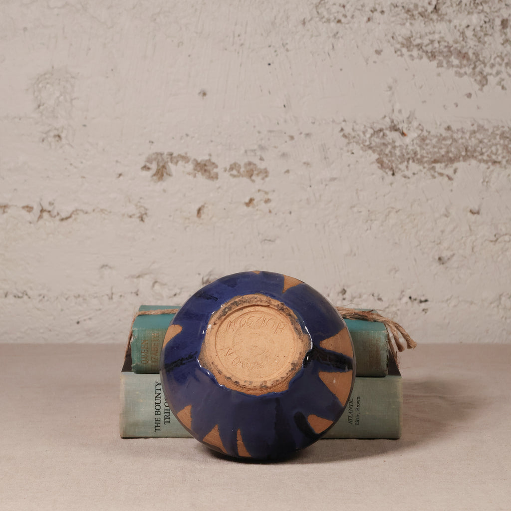 Ceramic dish with blue and brown design on a textured surface