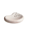 A small organic-shaped ceramic jewelry tray in a speckled cream-beige glaze, holding a delicate gold chain necklace, set on a white surface against a neutral beige background.